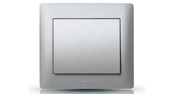 Ein silberner Lichtschalter der Marke Legrand, quadratische Form, modernes und schlichtes Design.